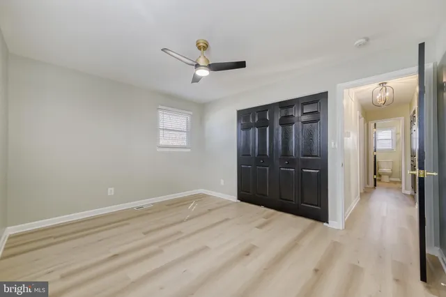 a view of a livingroom with a chandelier fan and wooden floor