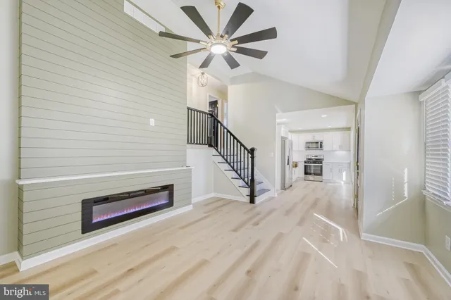 a view of a livingroom with wooden floor and a ceiling fan