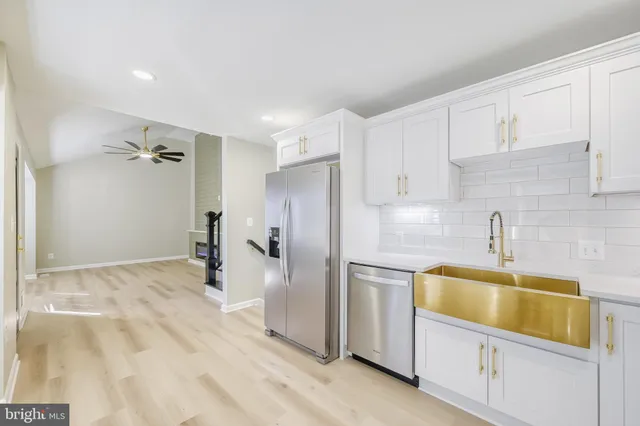 a bathroom with a sink a refrigerator and cabinets