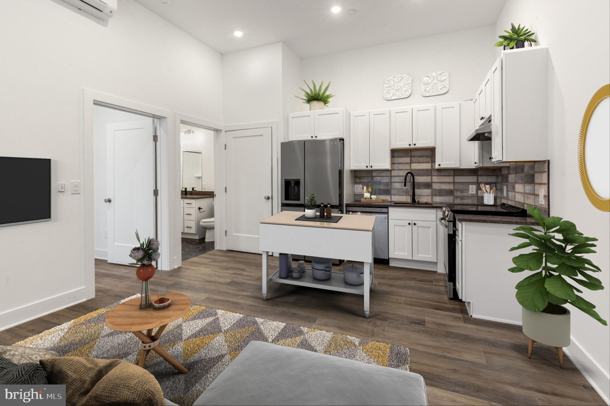 a living room with kitchen island furniture and a flat screen tv