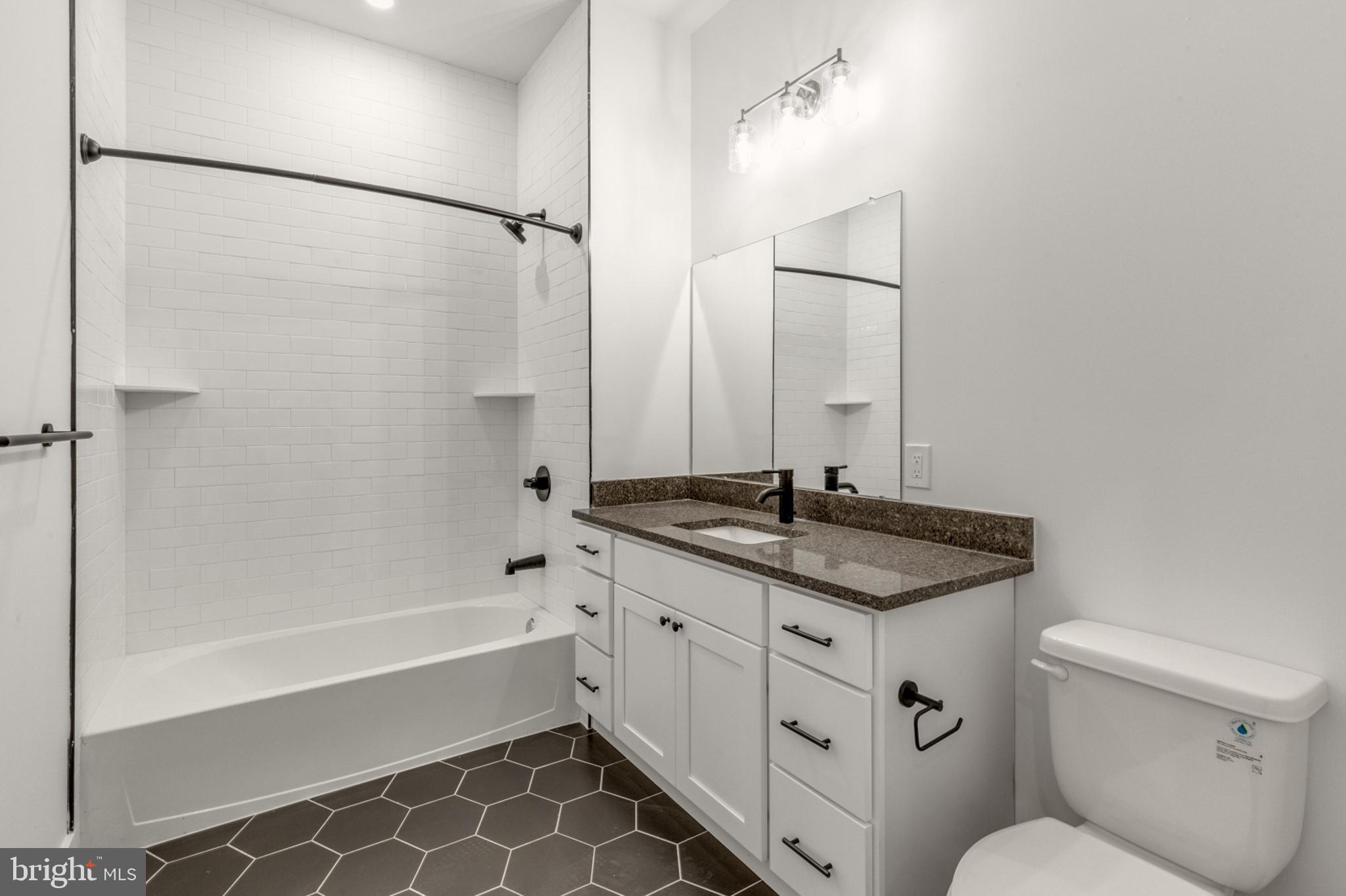 2214 North Front Street, Unit 101 Philadelphia, PA 19133 - Photo 11 of 22 a bathroom with a granite countertop sink toilet and shower