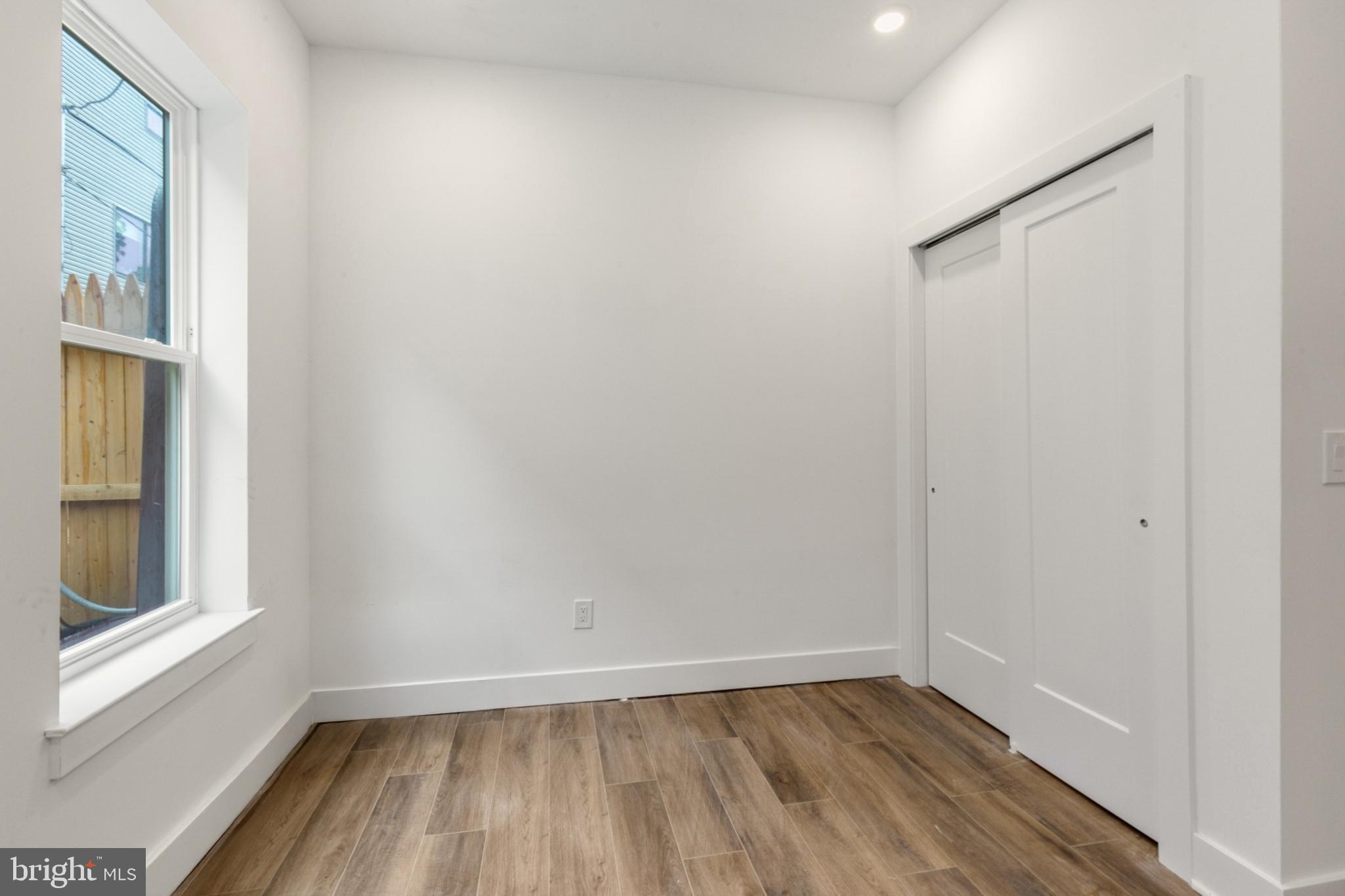 2214 North Front Street, Unit 101 Philadelphia, PA 19133 - Photo 14 of 22 a view of an empty room with wooden floor and a window