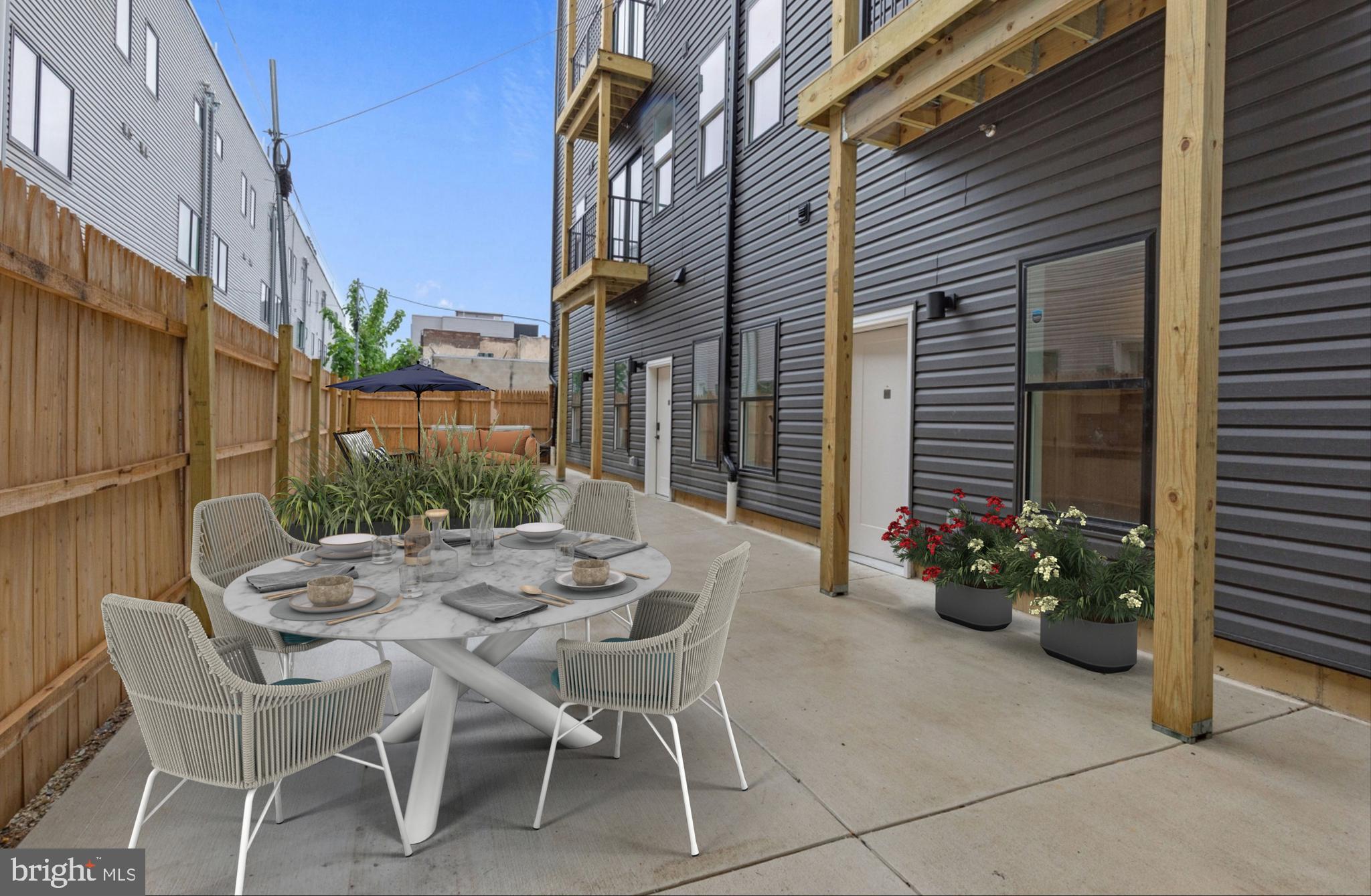 2214 North Front Street, Unit 101 Philadelphia, PA 19133 - Photo 3 of 22 a view of a patio with a table and chairs and potted plants