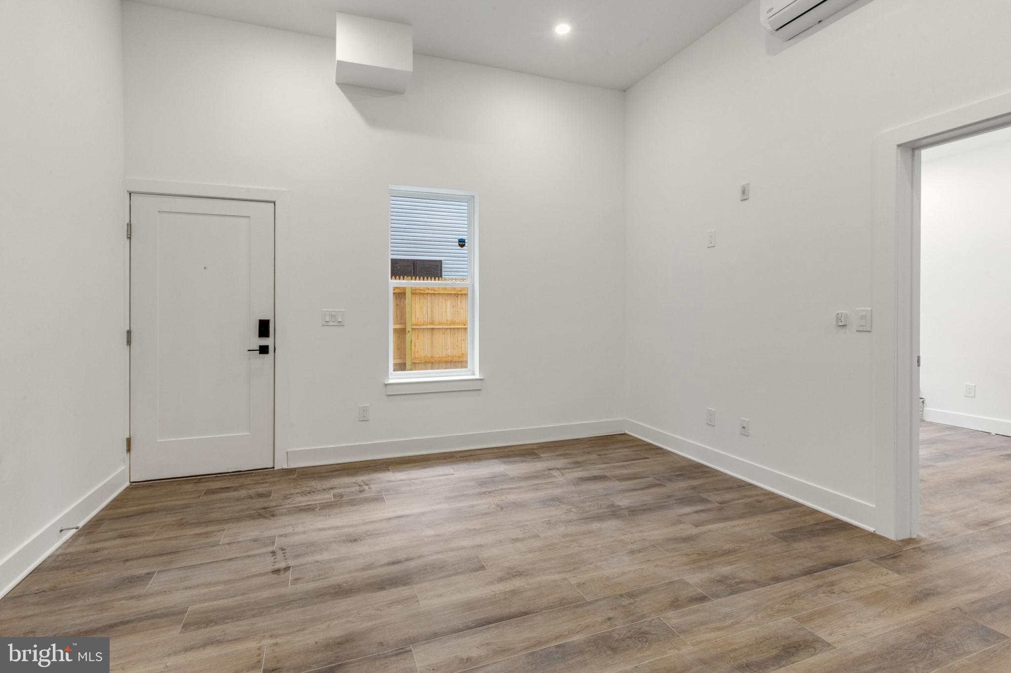 2214 North Front Street, Unit 101 Philadelphia, PA 19133 - Photo 7 of 22 an empty room with wooden floor and windows