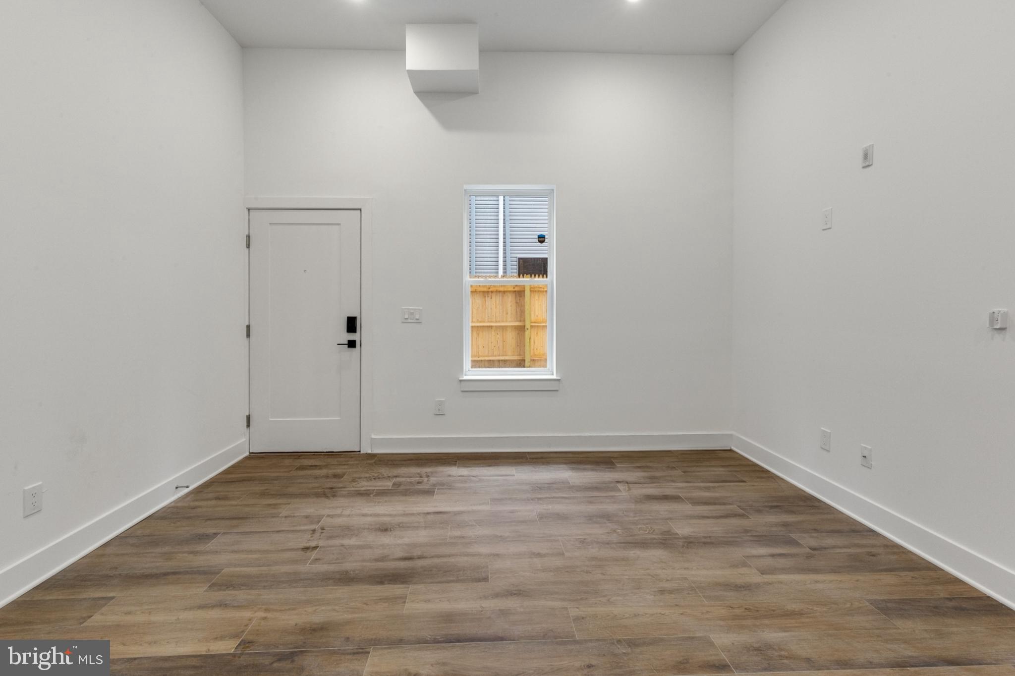 2214 North Front Street, Unit 101 Philadelphia, PA 19133 - Photo 8 of 22 a view of an empty room with wooden floor and a window