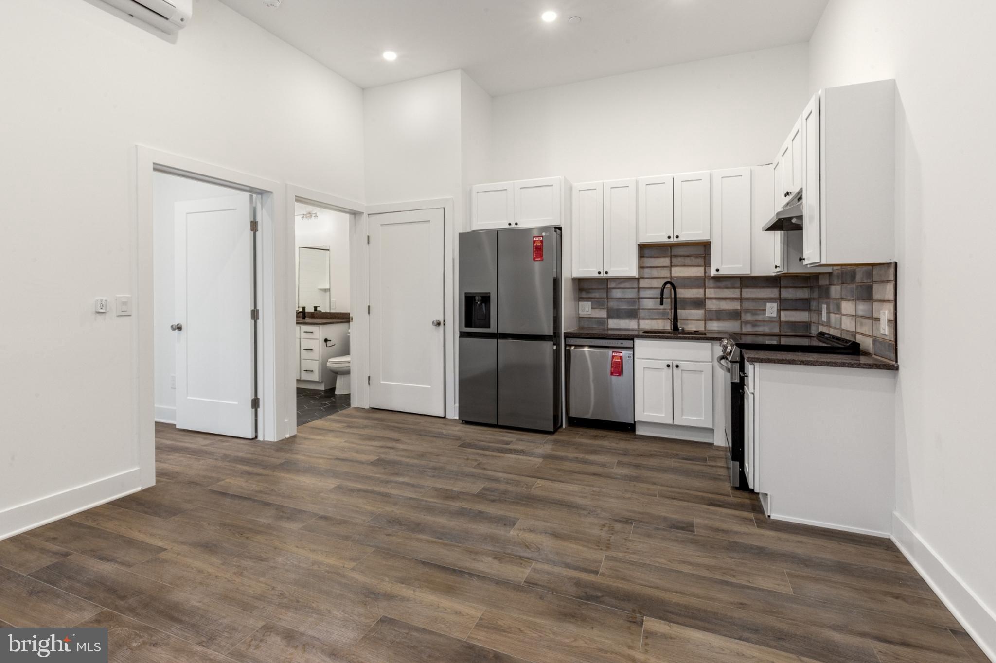 2214 North Front Street, Unit 101 Philadelphia, PA 19133 - Photo 9 of 22 a kitchen with stainless steel appliances granite countertop a refrigerator and a stove top oven