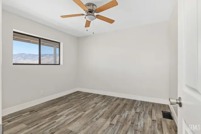 an empty room with a window and wooden floor