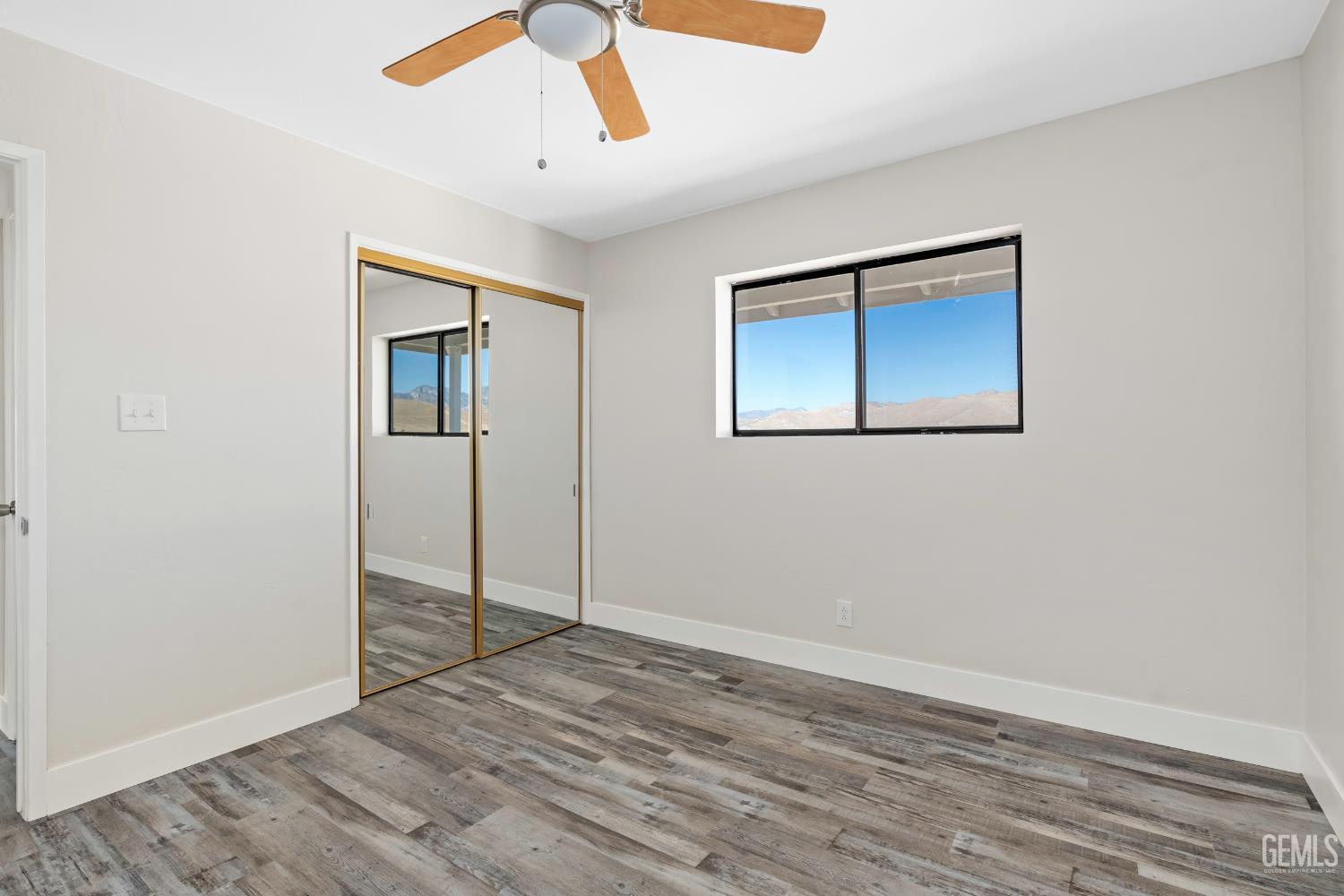 Undisclosed Address Weldon, CA 93283 - Photo 23 of 48 a view of an empty room with wooden floor and a ceiling fan