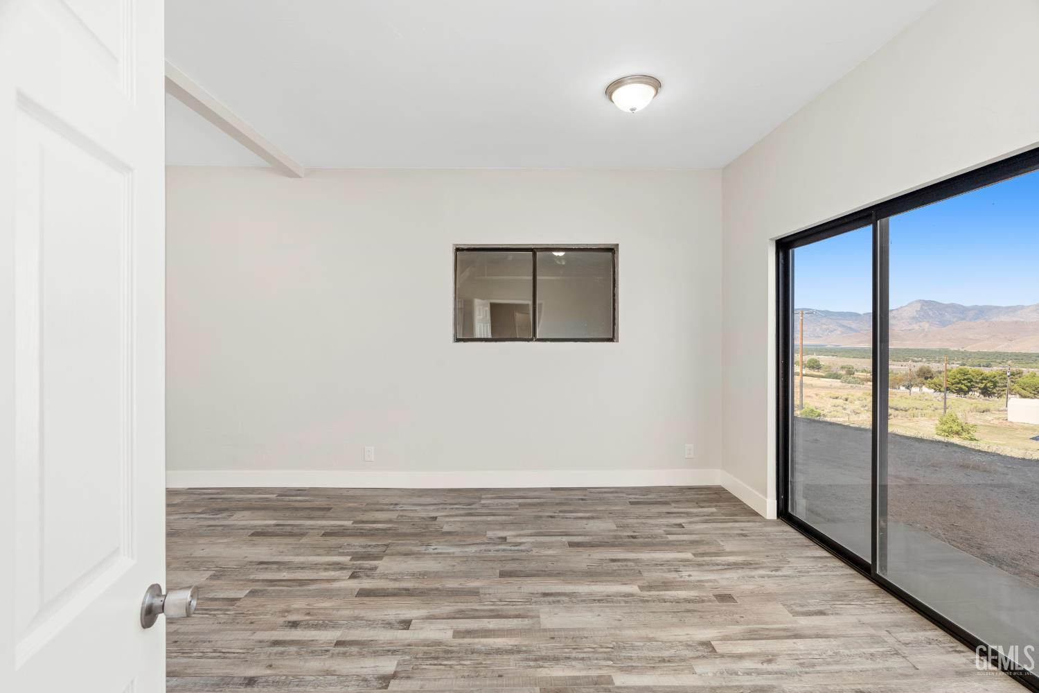 Undisclosed Address Weldon, CA 93283 - Photo 25 of 48 a view of an empty room with wooden floor and a window