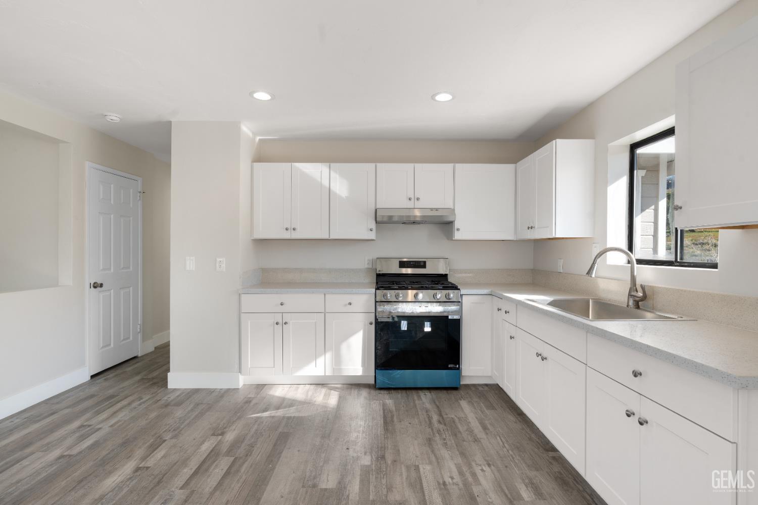 Undisclosed Address Weldon, CA 93283 - Photo 39 of 48 a large kitchen with granite countertop a stove top oven a sink and dishwasher with wooden floor