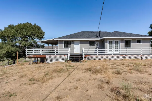 a view of a house with backyard and chairs