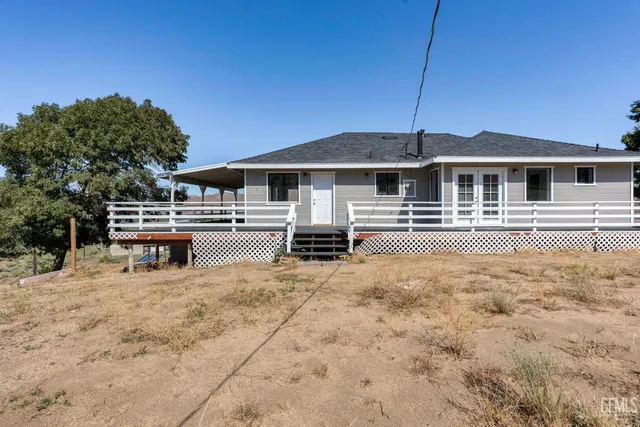a view of a house with backyard and chairs