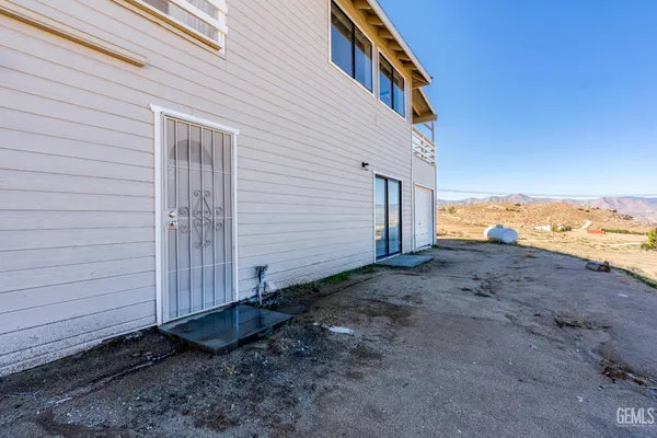 a view of a dry yard with wooden fence