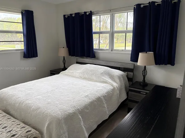 a large bed in a bedroom next to a window