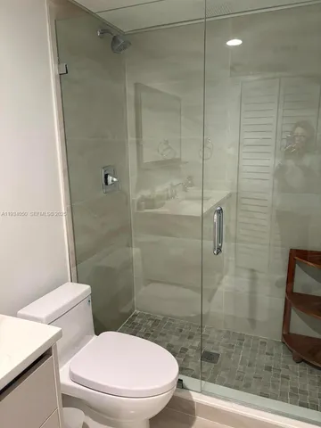 a white toilet and shower
