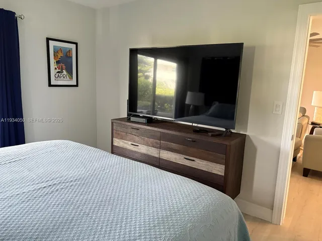 a bedroom with a bed and a flat screen tv