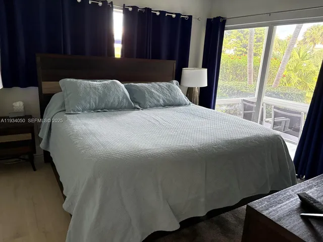 a bedroom with a bed window and wooden floor