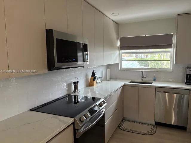 a kitchen with a sink a stove and cabinets
