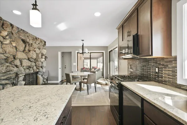 a kitchen with stainless steel appliances granite countertop a sink a stove counter space and cabinets