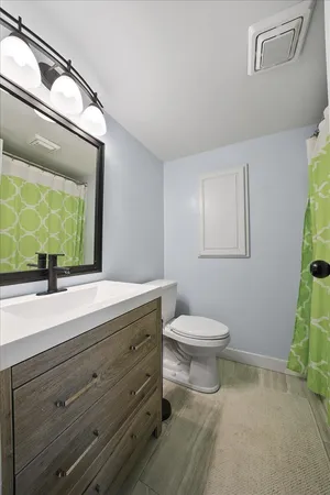 a bathroom with a toilet a sink and mirror
