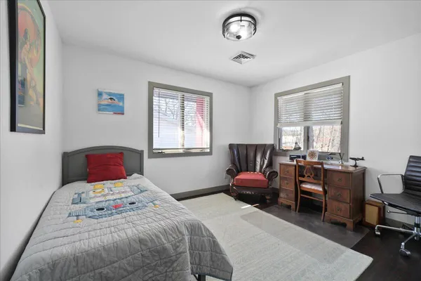 a bedroom with a bed chair and a window