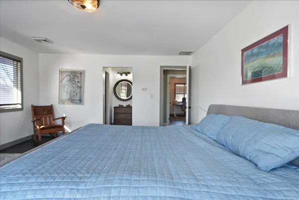 a large bedroom with a bed and wooden floor