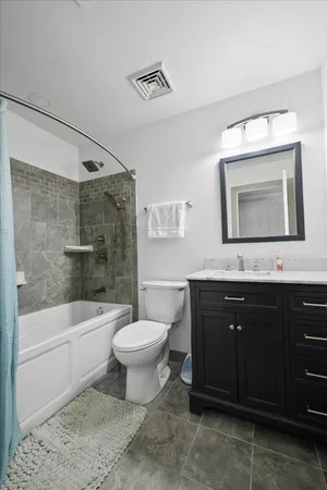 a bathroom with a bathtub shower sink mirror and toilet