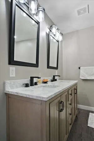 a bathroom with a granite countertop sink a large mirror and vanity