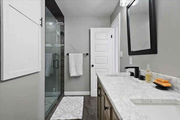 a bathroom with a granite countertop sink and a mirror