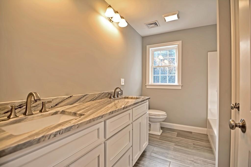 115 High Street Medfield, MA 02052 - Photo 31 of 42 a bathroom with a granite countertop sink mirror vanity and a toilet