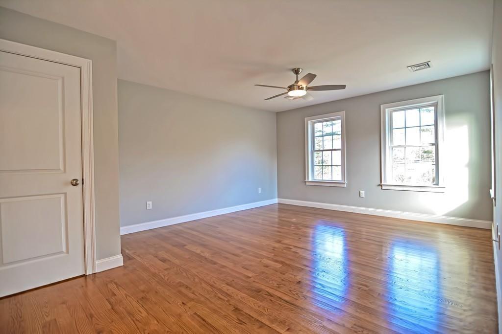 115 High Street Medfield, MA 02052 - Photo 33 of 42 an empty room with wooden floor chandelier fan and windows