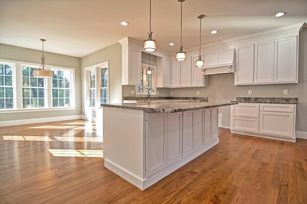 115 High Street Medfield, MA 02052 - Photo 6 of 42 a large kitchen with granite countertop a stove a sink and white cabinets with wooden floor