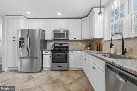 a kitchen with stainless steel appliances granite countertop a refrigerator sink and stove