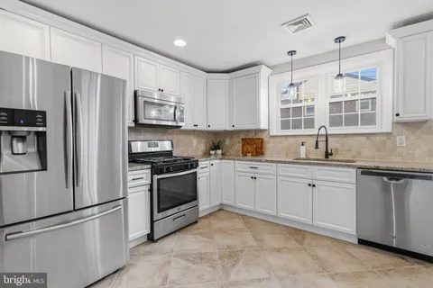 a kitchen with granite countertop stainless steel appliances and refrigerator