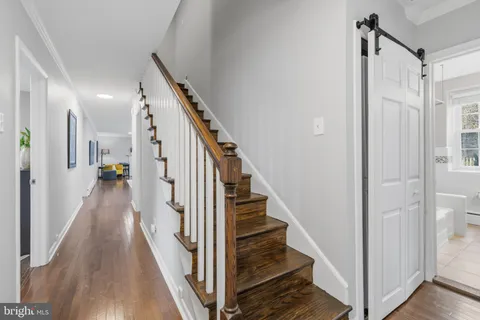 a view of a hallway with wooden floor and staircase