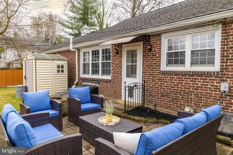 a view of a patio with couches table and chairs and wooden floor