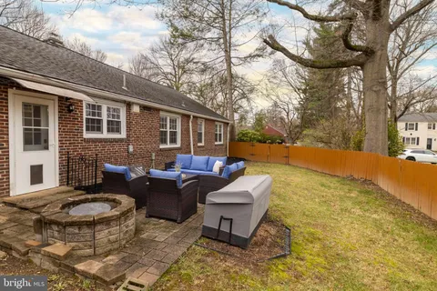 a view of a patio with couches table and chairs with wooden fence and plants