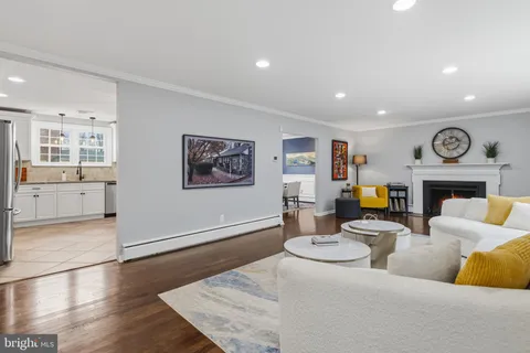 a living room with furniture kitchen view and a fireplace