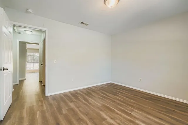 a view of a small space with wooden floor and a bathroom