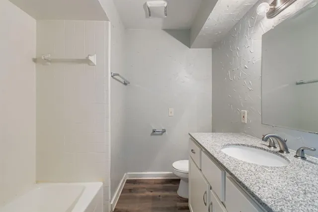 a bathroom with a granite countertop sink toilet and shower