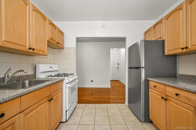 a kitchen with stainless steel appliances granite countertop a refrigerator and a stove