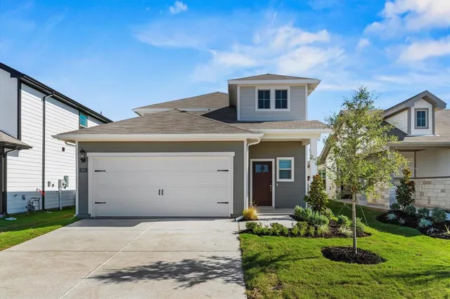 a front view of a house with a yard garage and outdoor seating