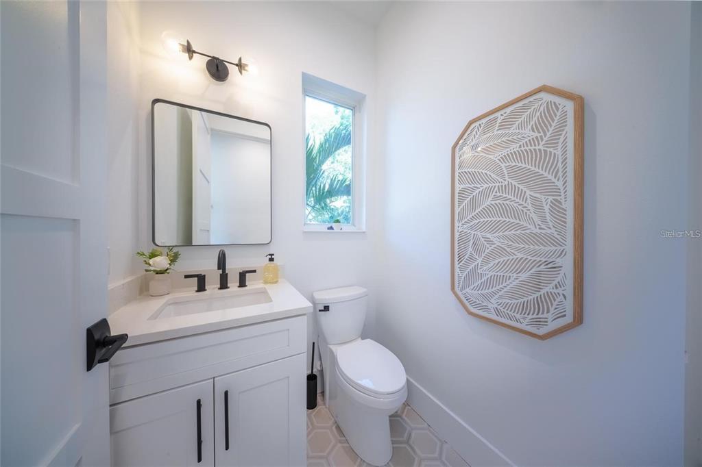 2446 Floyd Street Sarasota, FL 34239 - Photo 30 of 70 a bathroom with a toilet a sink a vanity and mirror