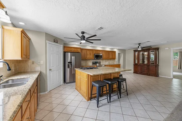 a kitchen with stainless steel appliances kitchen island granite countertop a sink and cabinets