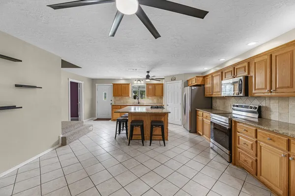 a kitchen with granite countertop white cabinets stainless steel appliances and a sink