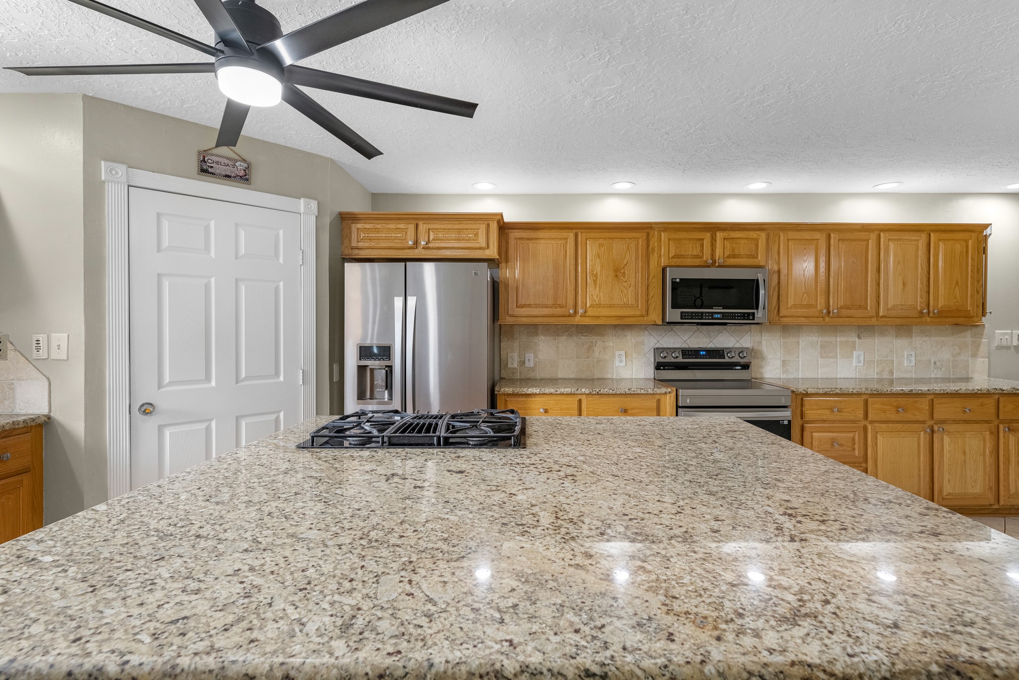 16511 Edgefield Lane Conroe, TX 77302 - Photo 18 of 42 a kitchen with stainless steel appliances granite countertop a stove a sink and a microwave
