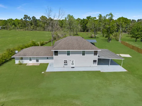 an aerial view of a house with swimming pool and a yard