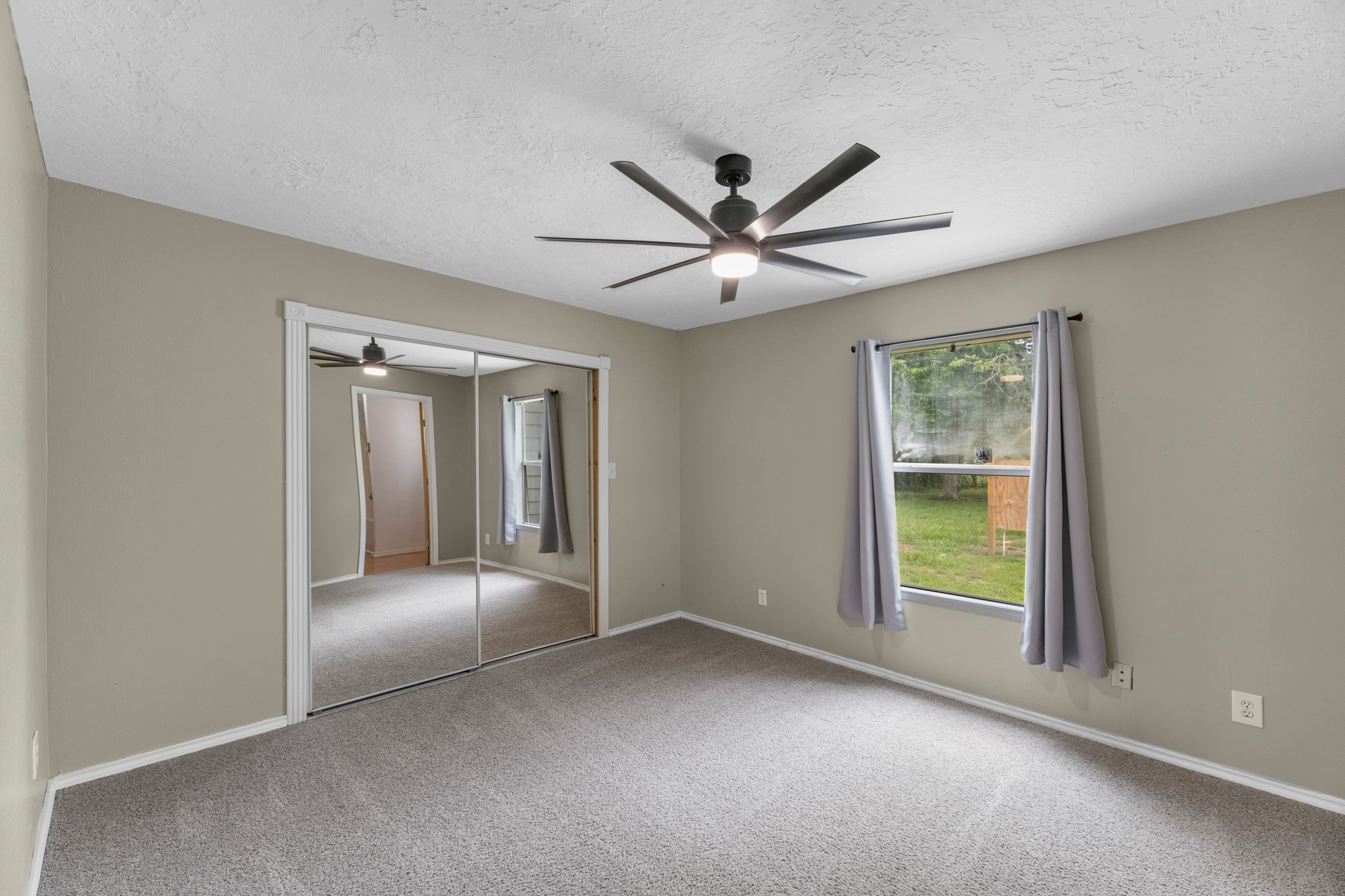 16511 Edgefield Lane Conroe, TX 77302 - Photo 21 of 42 an empty room with chandelier fan and windows