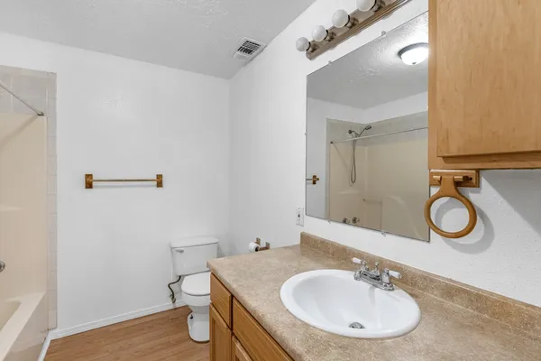 an empty room with a ceiling fan and windows