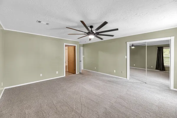 a view of an empty room with a ceiling fan